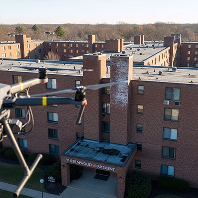 Aerial drone image of apartment complex roof inspection in Johnston, IA, near Des Moines. AI-generated.
