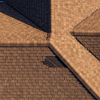 Aerial drone image showing a damaged residential roof during an inspection.