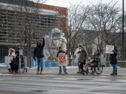 Protesters standing in the bitter cold snow in front of the Holidazzle Yeti statue at South 11th Street and Nicollet in downtown Minneapolis, Minnesota, holding signs protesting ICE violence and state-sponsored killings. January 20, 2026. (Photo by Awe Video & Photo Studio) Protesters standing in the snow in front of the Holidazzle Yeti statue at South 11th Street and Nicollet in downtown Minneapolis, Minnesota, holding signs protesting ICE violence and state-sponsored killings during January 2026. (Photo by Awe Video & Photo Studio)