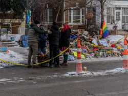 Community members and visitors huddled around an open pit fire at the Renee Good Roadside Memorial in Minneapolis to keep warm during a winter vigil for the slain mother of three, ages 15, 12, and 6. January 20, 2026 (Photo by Awe Video & Photo Studio) Community members and visitors huddled around an open pit fire at the Renee Good Roadside Memorial in Minneapolis to keep warm during a winter vigil for the slain mother of three, ages 15, 12, and 6. January 20, 2026 (Photo by Awe Video & Photo Studio)